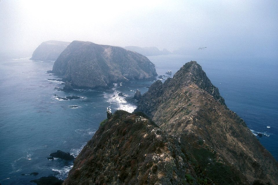 A knife-edge ridge in the foreground running toward the island's middle and western sections, in sea fog