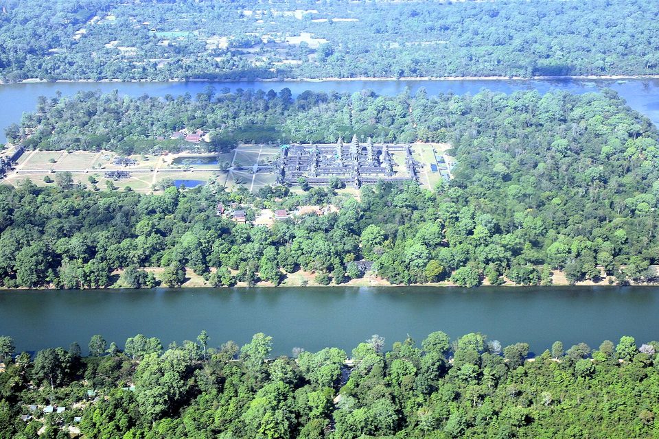 A rectangle of temple buildings among trees inside a wide moat, forest on all sides