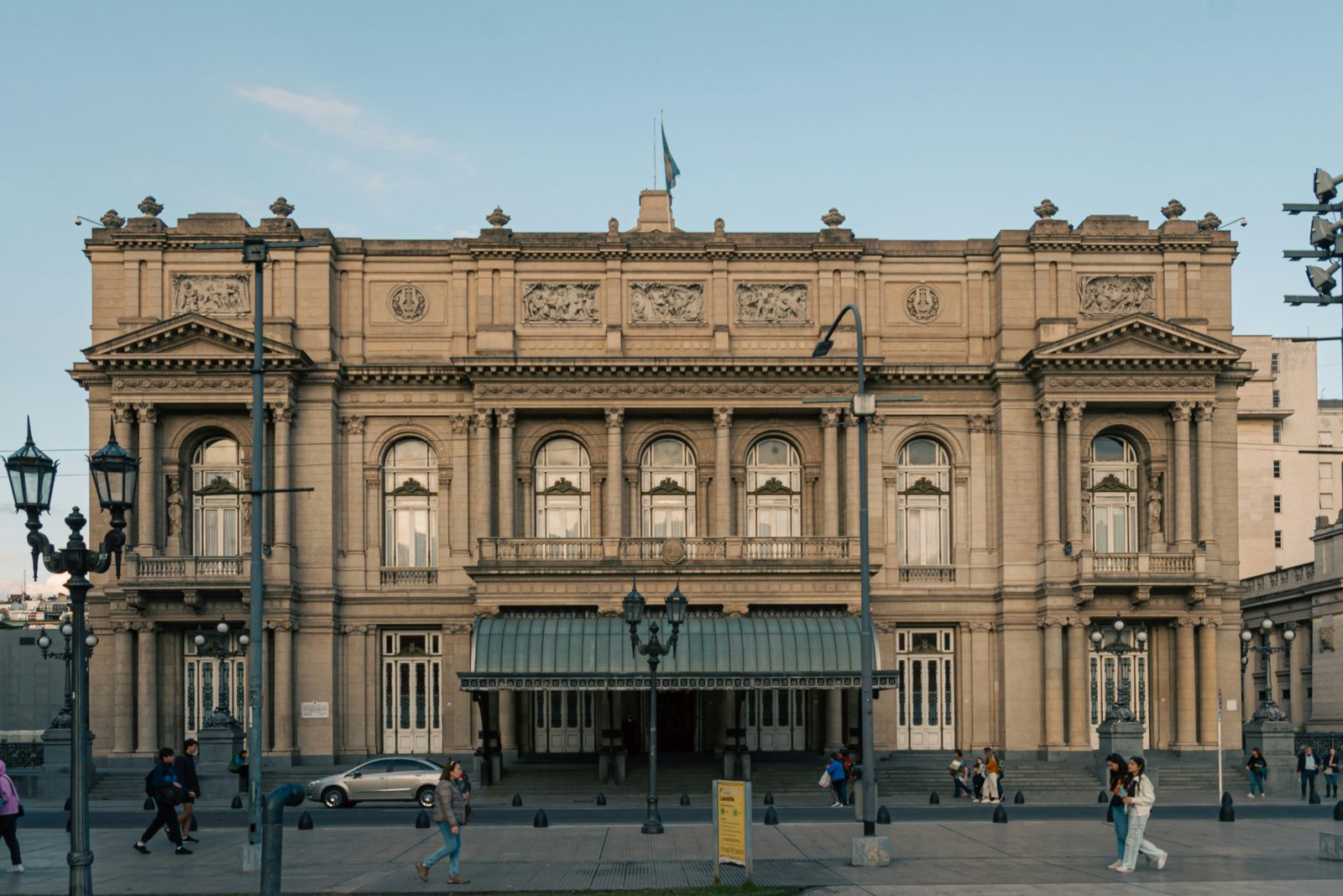 The classical stone façade of an opera house in soft evening light