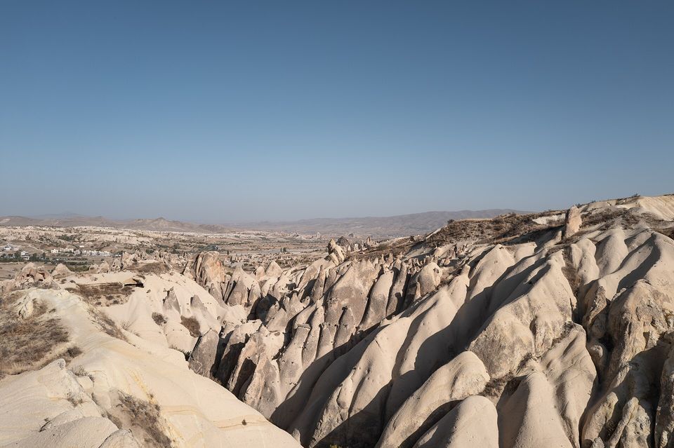 Ridged pink-and-cream rock valleys under a clear sky