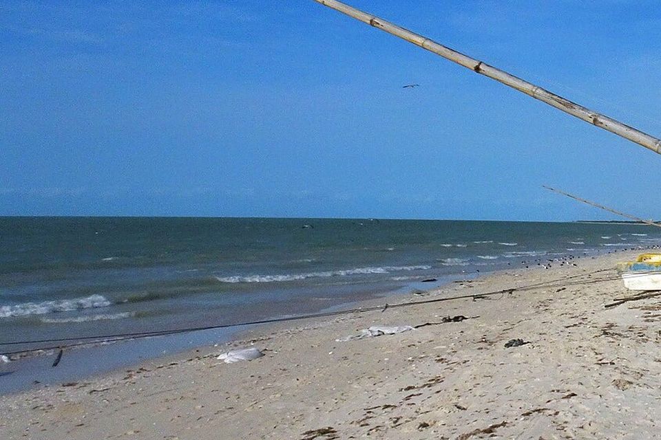 A sandy beach with fishing boats drawn up on it