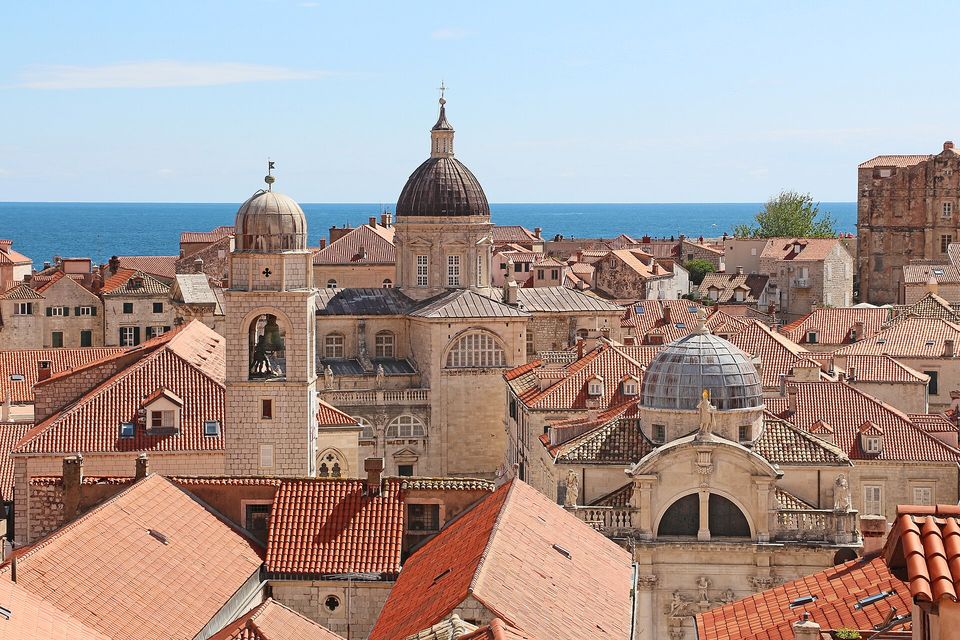 Terracotta roofs with baroque domes and bell towers beside the sea