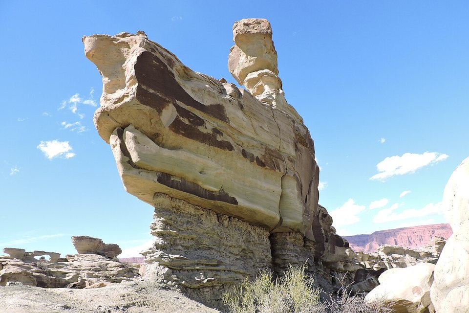 A wind-cut sandstone ledge with a conning-tower shape under a blue sky