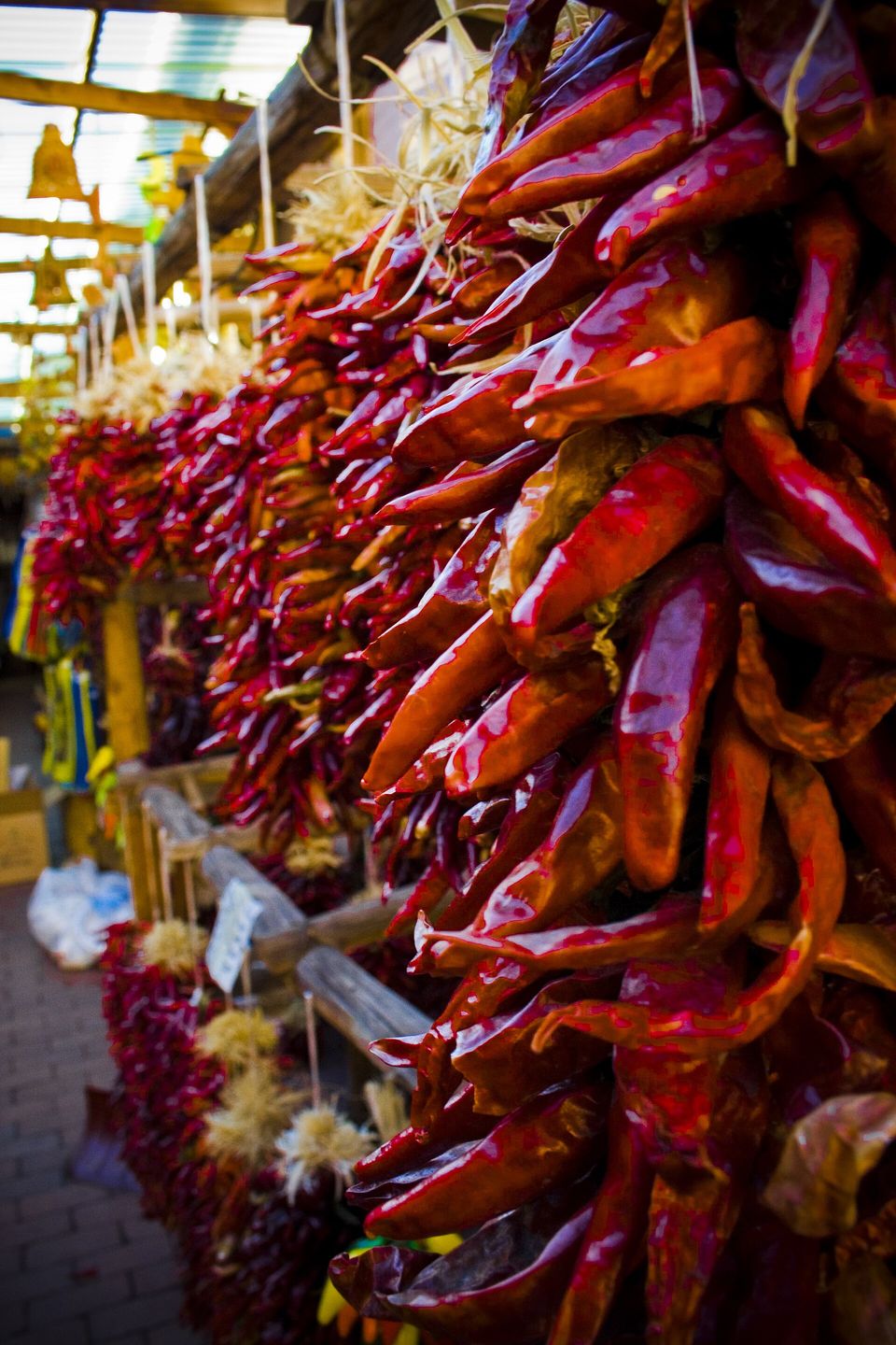 Long strings of dried red chiles hanging from a wooden portal beam