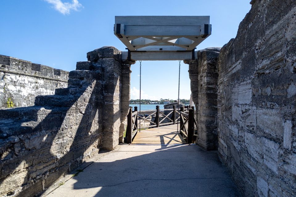A gate passage through a thick stone wall, with the bay visible at the far end