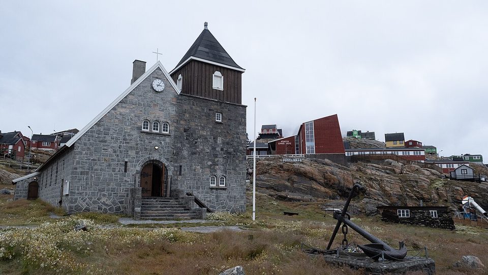 A church built of grey granite with an anchor beside it