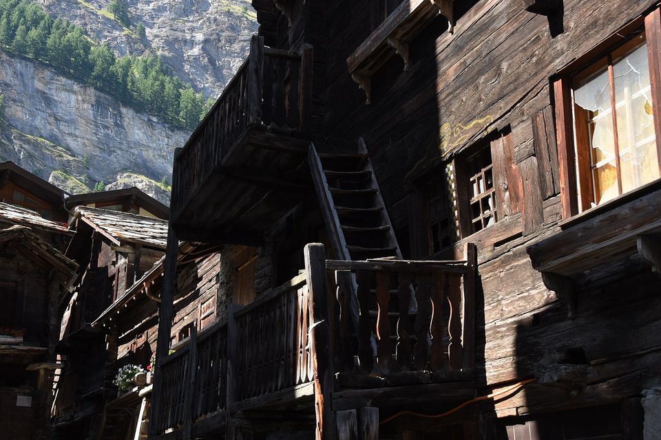 Sun-darkened timber houses with outside stairs and balconies in a village lane